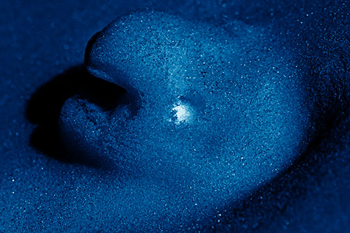 Glowing Eyed Snow Face Emerges Above Soil (Blue Shade)