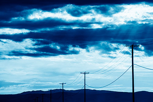 Powerline Silhouette Entering Mountain Range (Blue Shade Photo)