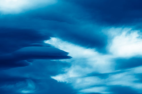 Smooth Cloud Sails Along Swirling Formations (Blue Shade Photo)