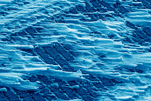 Snow Drifts Atop Rigid Pavement (Blue Shade Photo)