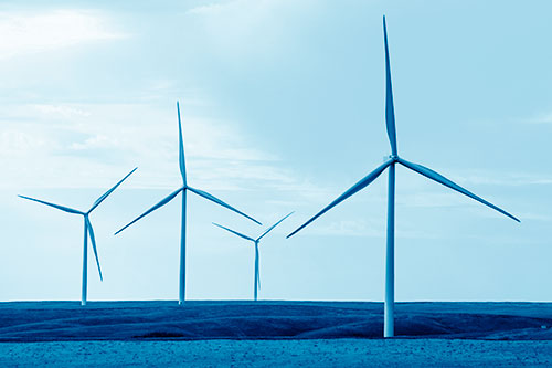 Wind Turbines Standing Tall Among Grassy Pasture (Blue Shade)