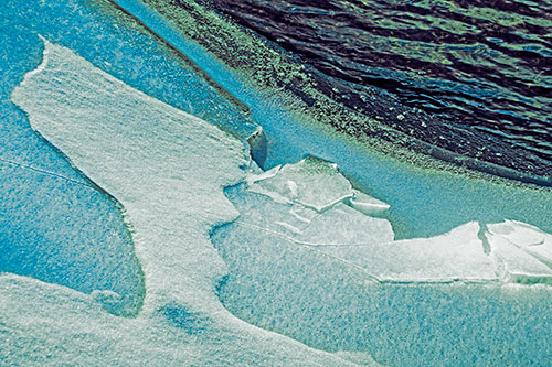 Broken Cracked Ice Along Shoreline (Blue Tint Photo)