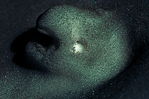 Glowing Eyed Snow Face Emerges Above Soil (Blue Tint)