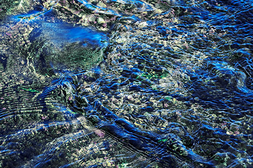 Large Algae Rock Creating River Water Ripples (Blue Tint Photo)