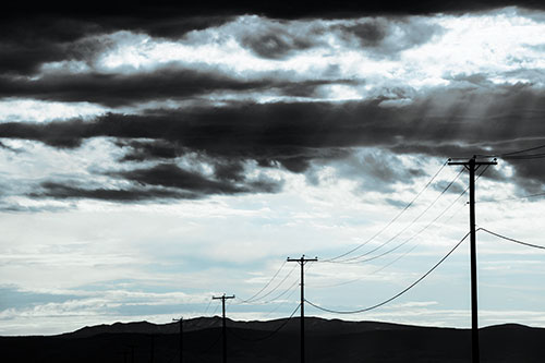 Powerline Silhouette Entering Mountain Range (Blue Tint Photo)