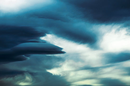 Smooth Cloud Sails Along Swirling Formations (Blue Tint Photo)