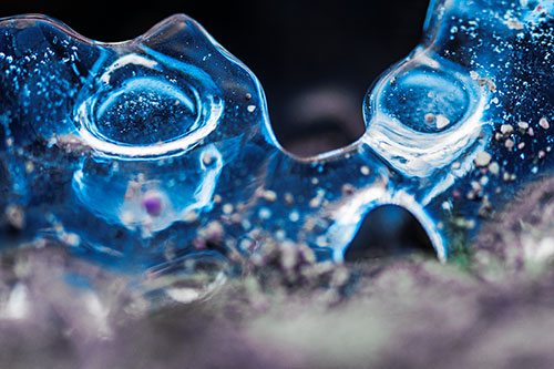 Vertical Bubble Eyed Screaming Ice Face Along Frozen River (Blue Tint Photo)