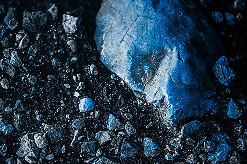 Alien Skull Rock Face Emerging Atop Dirt Surface (Blue Tone Photo)
