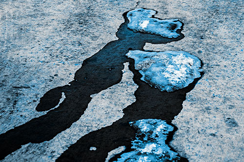 Melting Ice Puddles Forming Water Streams (Blue Tone Photo)