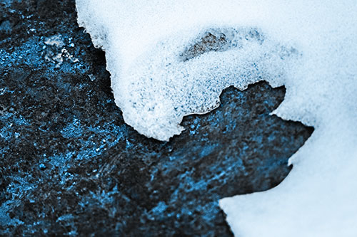 Screaming Snow Face Slowly Melting Atop Rock Surface (Blue Tone Photo)