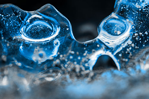 Vertical Bubble Eyed Screaming Ice Face Along Frozen River (Blue Tone Photo)
