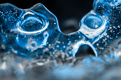 Vertical Bubble Eyed Screaming Ice Face Along Frozen River (Blue Tone)