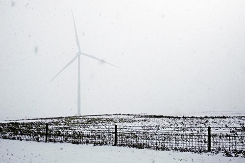 Fenced Wind Turbine Among Blowing Snow