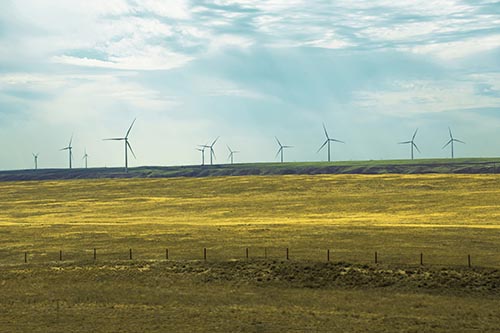 Wind Turbines Scattered Along The Prairie Horizon