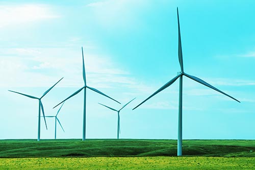 Wind Turbines Standing Tall On Green Pasture