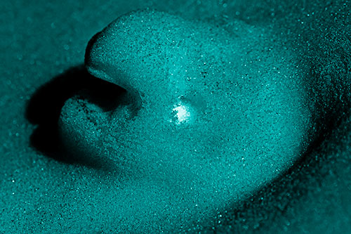 Glowing Eyed Snow Face Emerges Above Soil (Cyan Shade)