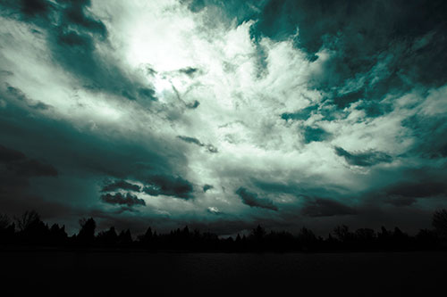 Clouds Spiraling Above Dark Lit Lake (Cyan Tint Photo)