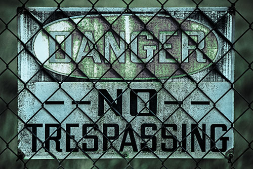 Dirty Danger No Trespassing Sign Behind Chain Link Fence (Cyan Tint)