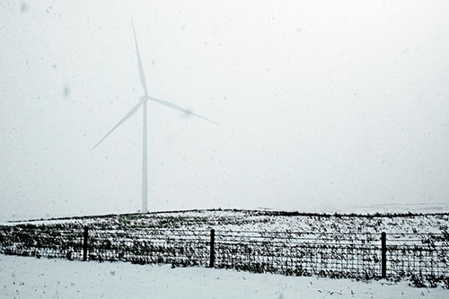 Fenced Wind Turbine Among Blowing Snow (Cyan Tint Photo)