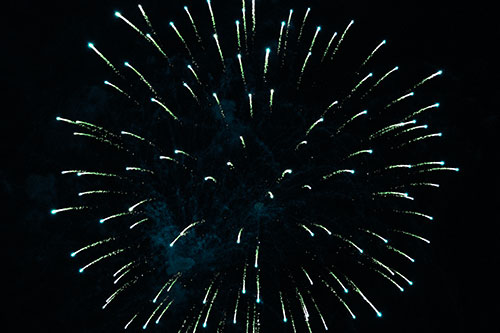 Firework Star Trails Vaporize Among Night Sky (Cyan Tint Photo)