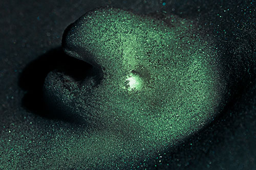Glowing Eyed Snow Face Emerges Above Soil (Cyan Tint)