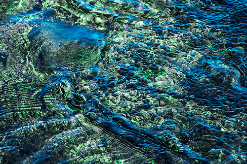 Large Algae Rock Creating River Water Ripples (Cyan Tint Photo)