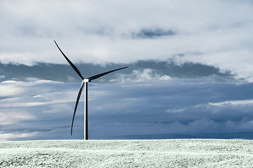 Lone Wind Turbine Standing Along Dry Prairie Horizon (Cyan Tint Photo)