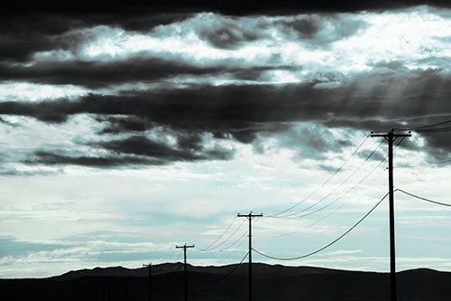 Powerline Silhouette Entering Mountain Range (Cyan Tint Photo)