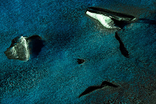 Sad Teardrop Ice Face Appears Atop Frozen River (Cyan Tint Photo)