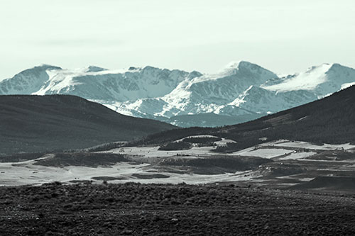 Snow Capped Mountains Behind Hills (Cyan Tint Photo)