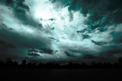 Clouds Spiraling Above Dark Lit Lake (Cyan Tone Photo)