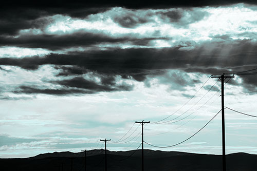 Powerline Silhouette Entering Mountain Range (Cyan Tone Photo)