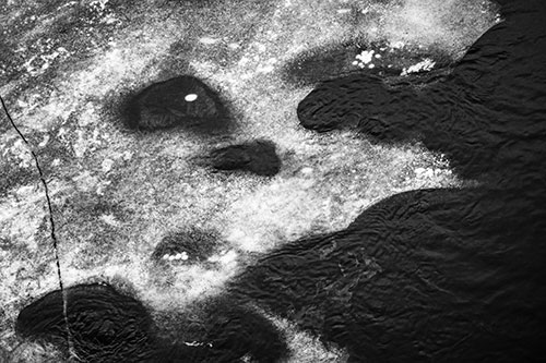 Disintegrating Ice Face Melting Among Flowing River Water (Gray Photo)