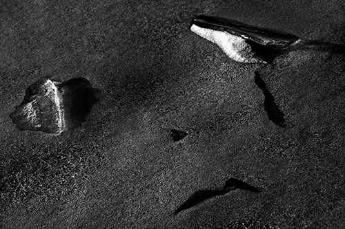 Sad Teardrop Ice Face Appears Atop Frozen River (Gray Photo)