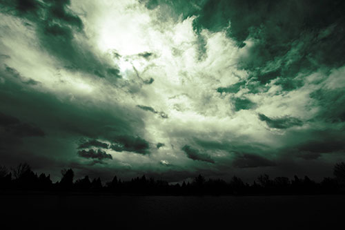 Clouds Spiraling Above Dark Lit Lake (Green Tint Photo)