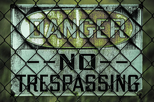 Dirty Danger No Trespassing Sign Behind Chain Link Fence (Green Tint)