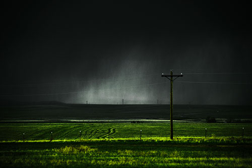 Distant Thunderstorm Rains Down Upon Powerlines (Green Tint Photo)