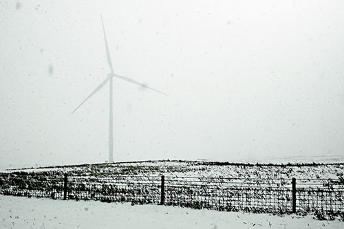 Fenced Wind Turbine Among Blowing Snow (Green Tint Photo)