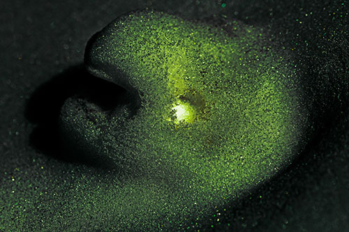 Glowing Eyed Snow Face Emerges Above Soil (Green Tint)