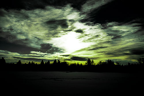 Sun Vortex Illuminates Clouds Above Dark Lit Lake (Green Tint Photo)