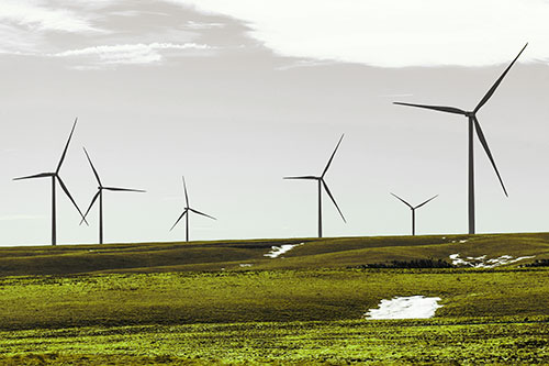 Wind Turbines Scattered Around Melting Snow Patches (Green Tint Photo)