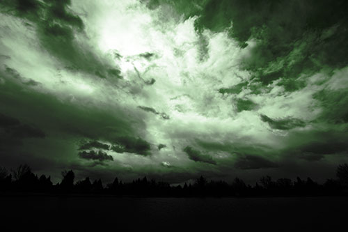 Clouds Spiraling Above Dark Lit Lake (Green Tone Photo)