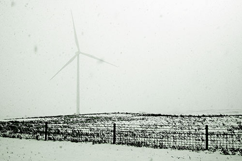 Fenced Wind Turbine Among Blowing Snow (Green Tone Photo)