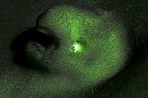 Glowing Eyed Snow Face Emerges Above Soil (Green Tone)