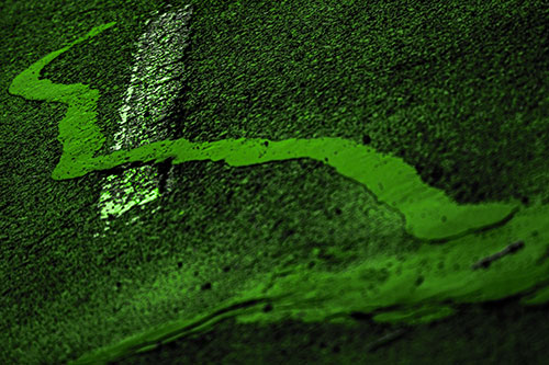 Slithering Tar Creeps Over Pavement Marking (Green Tone Photo)