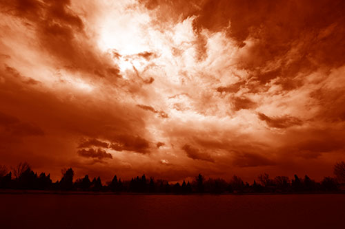 Clouds Spiraling Above Dark Lit Lake (Orange Shade Photo)