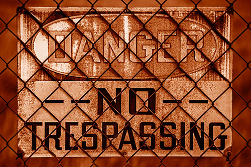 Dirty Danger No Trespassing Sign Behind Chain Link Fence (Orange Shade)