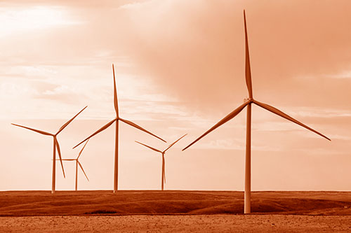 Wind Turbines Standing Tall On Green Pasture (Orange Shade Photo)