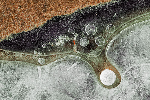 Ice Bubbles Among Frozen Soil Crevice (Orange Tint Photo)