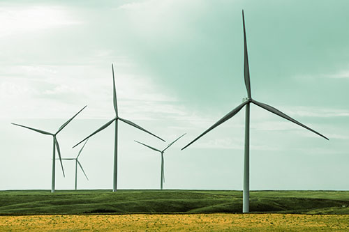 Wind Turbines Standing Tall On Green Pasture (Orange Tint Photo)